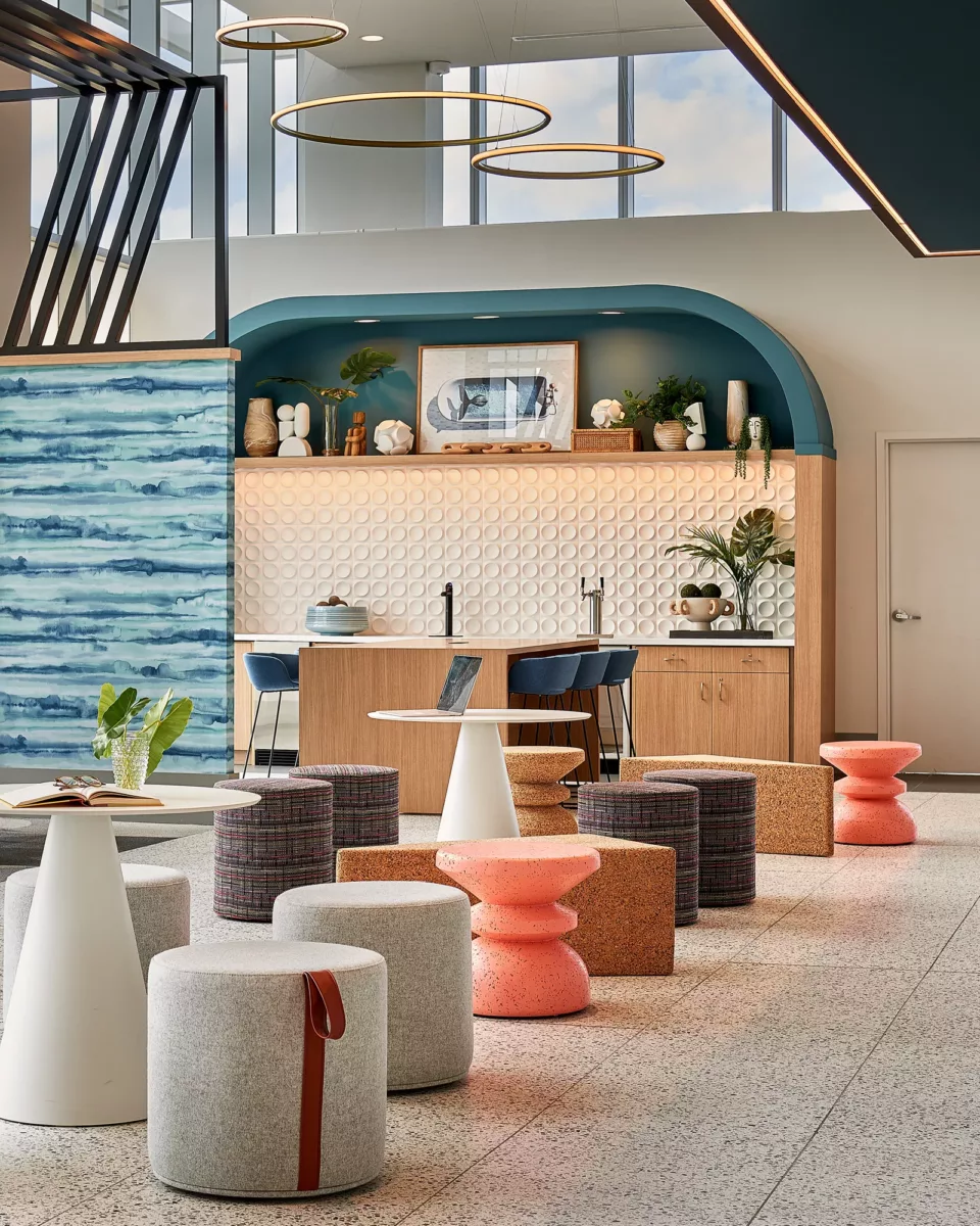 Resident lounge with café seating, curved bar, decorative shelving, and pendant lights.