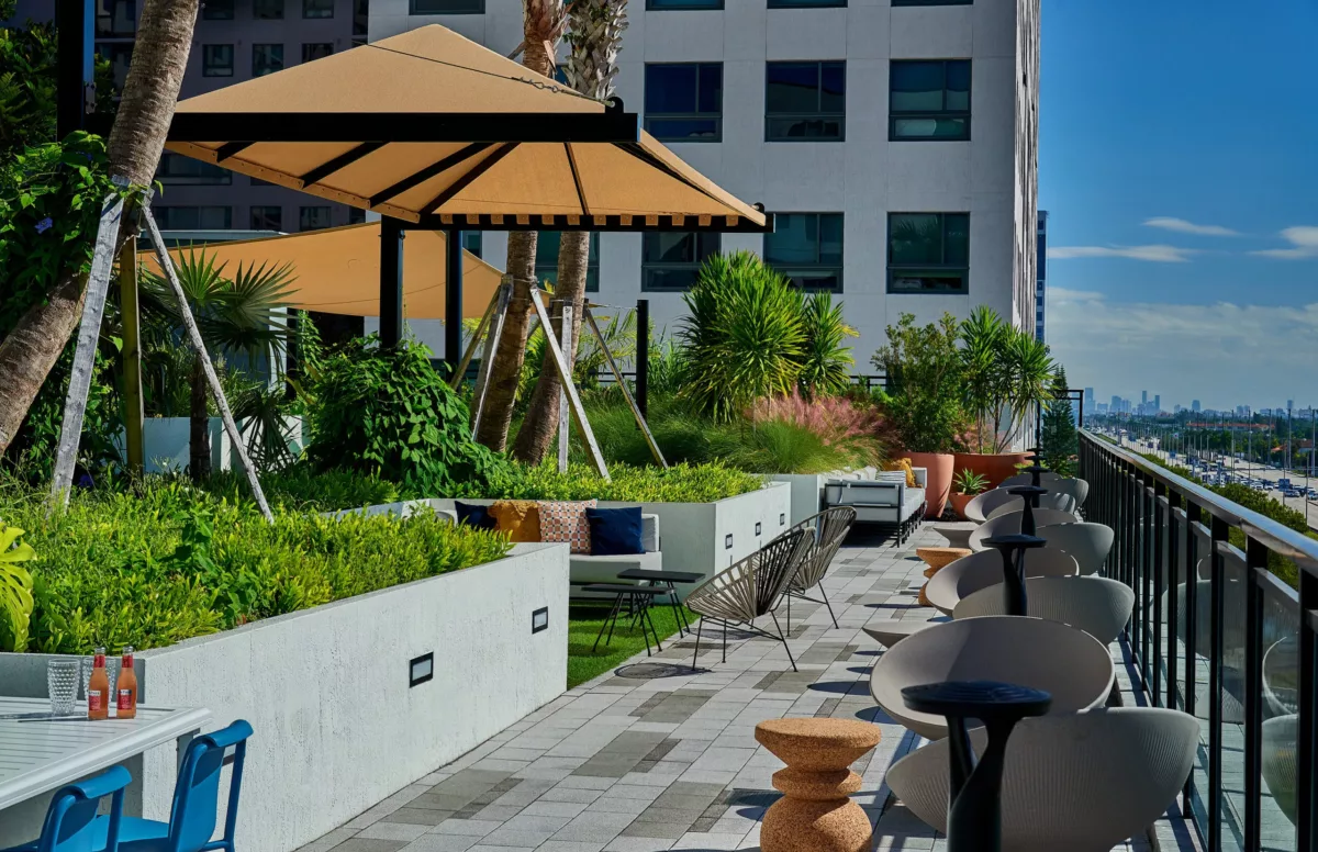 Rooftop terrace with shaded seating, planters, and city skyline views