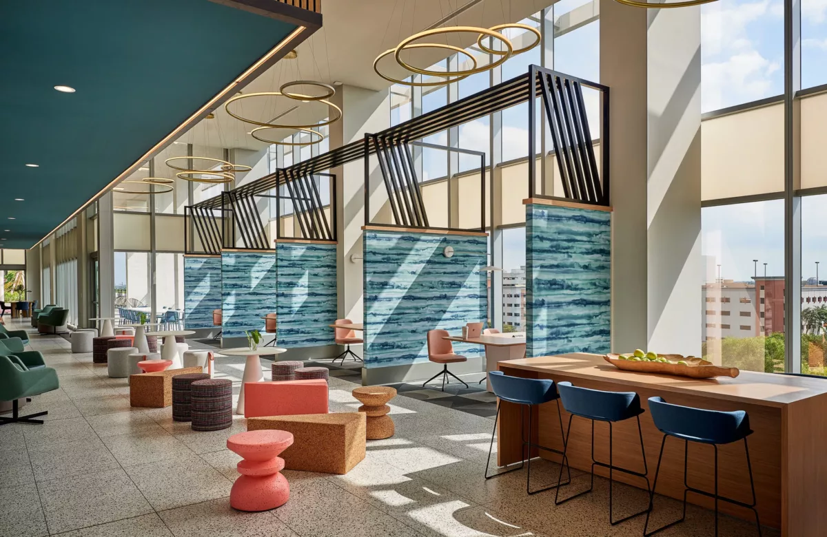Spacious clubhouse lounge with communal tables, bar seating, and large windows.