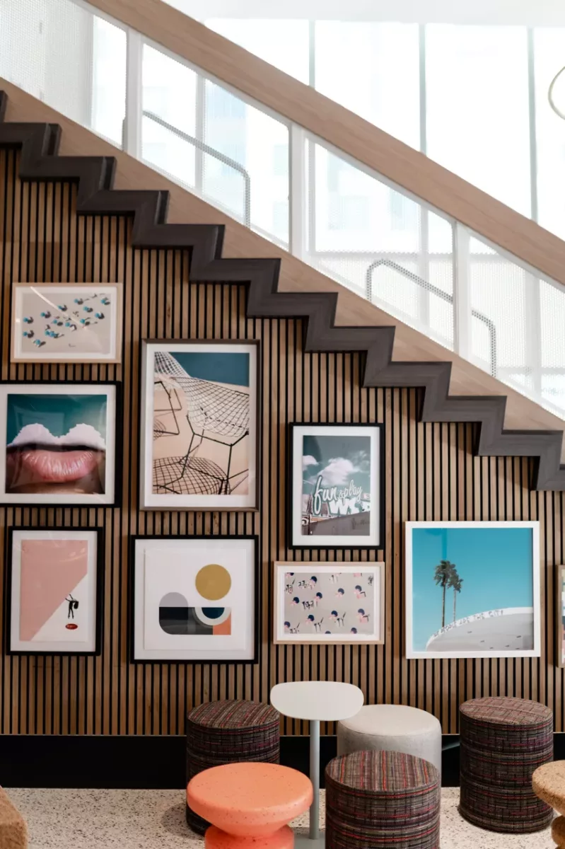 Interior stair wall with framed artwork gallery and small seating area